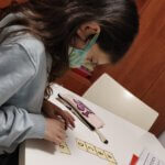 תמונה של ילדה כותבת על שולחן