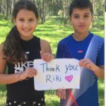 מיה ומעיין- שני ילדים עומדים עם שלט שכתוב עליו thank you