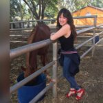 הדר יובל- אישה עומדת ליד גדר ומחייכת