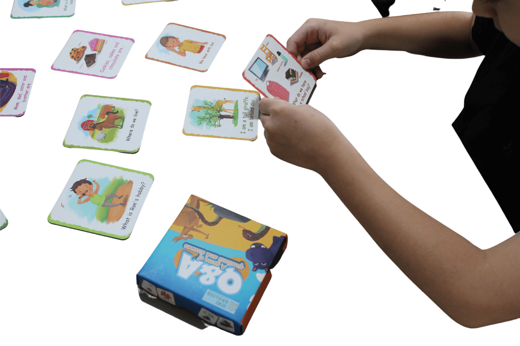 משחק q&a- ידיים של ילד מחזיקות קלף, וקלפים מסביבו